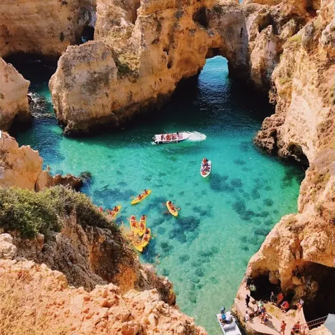 Kayakers paddling along the Algarve coast caves
